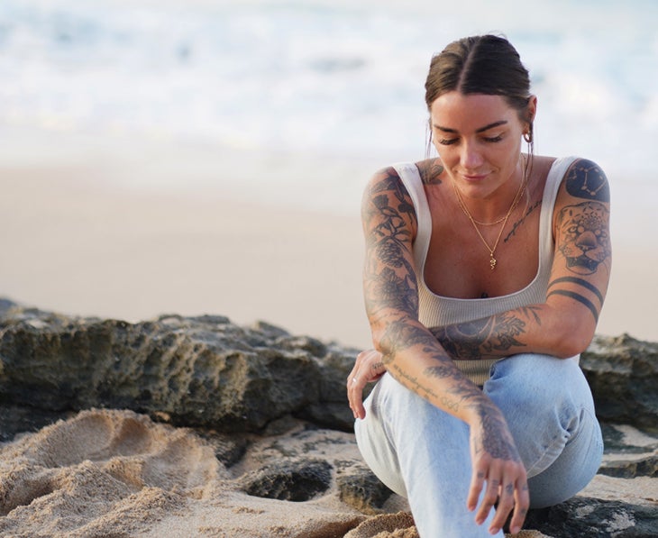 Woman with tattoos on the beach