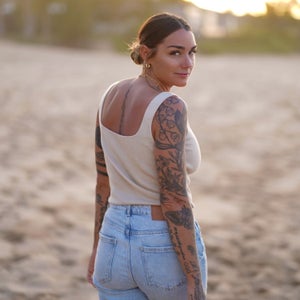 Author wearing a white shirt and jeans on a beach