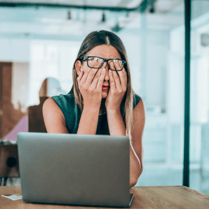 Woman at her laptop who needs to take a break because she is stressed by work deadlines
