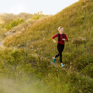 A trail runner runs along a path in a park.