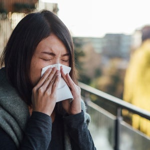 Woman sneezes during allergy season