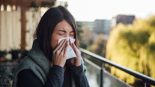 Woman sneezes during allergy season