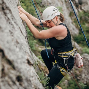 Woman climbs boulder with hypermobility