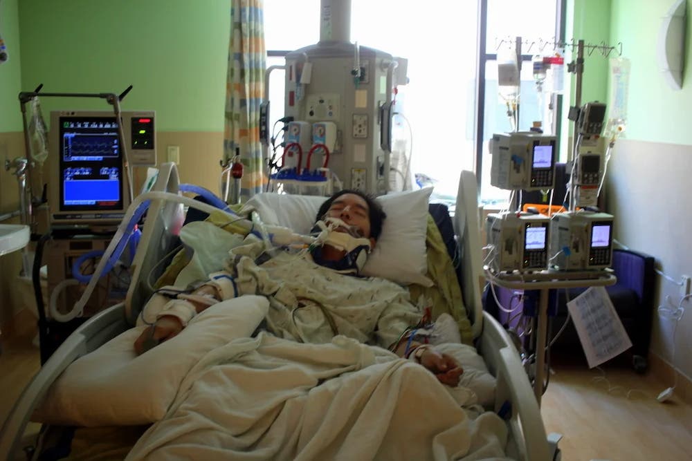 A man is in a coma hooked up tubes and in bed