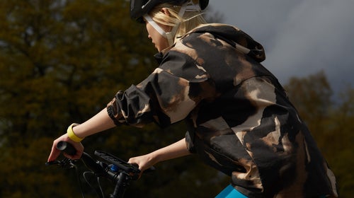 Woman rides a bike with an Apple watchos 10