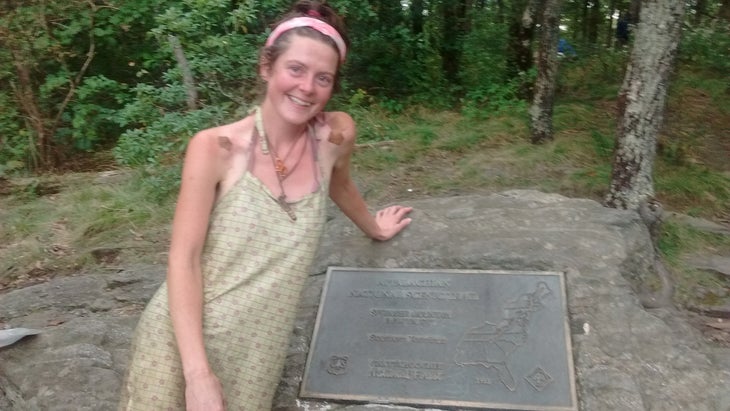 Heather Anderson poses next to a plaque marking the southern terminus of the AT.