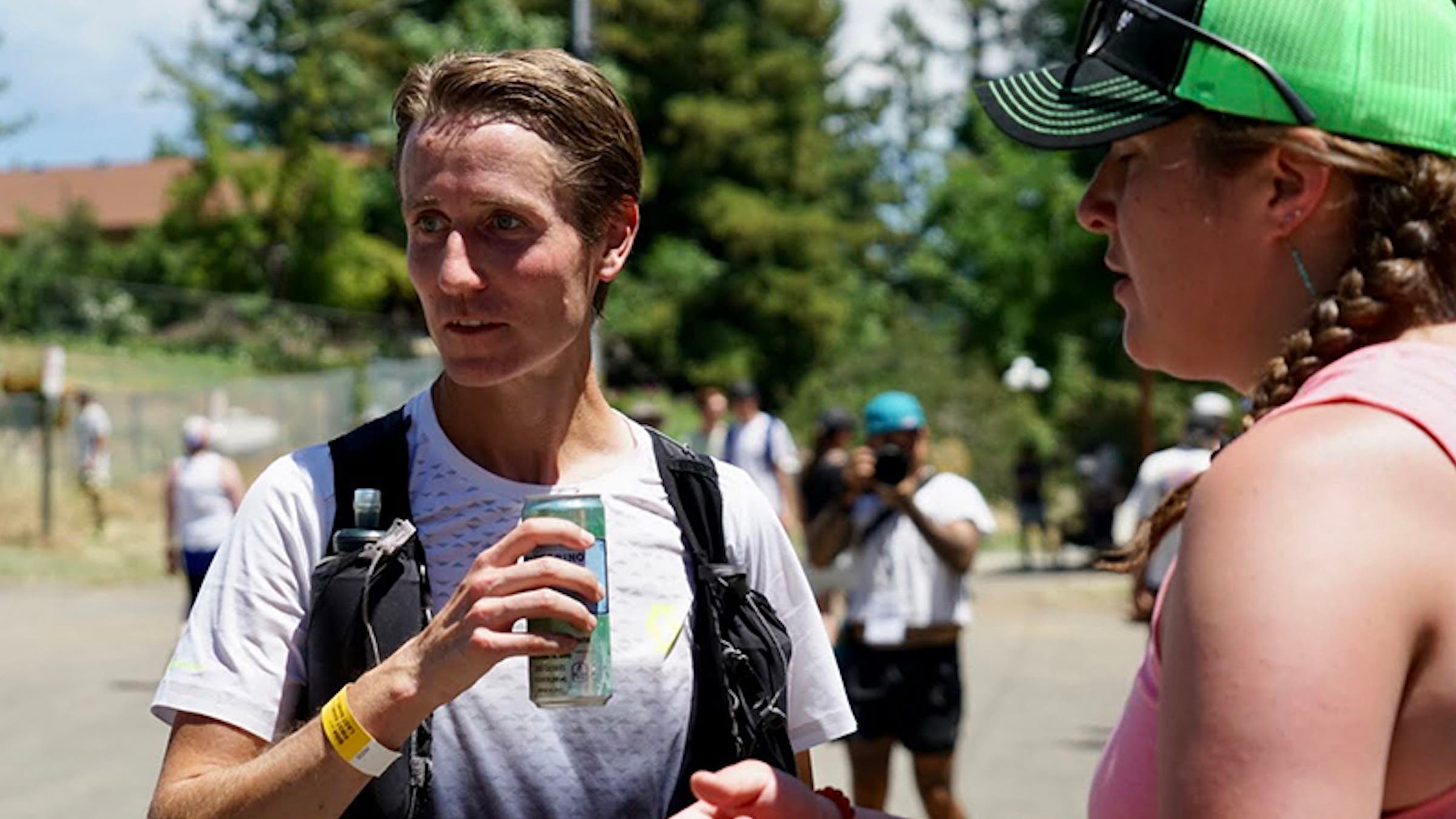 a man drinks a cold beverage on the Western States 100 course