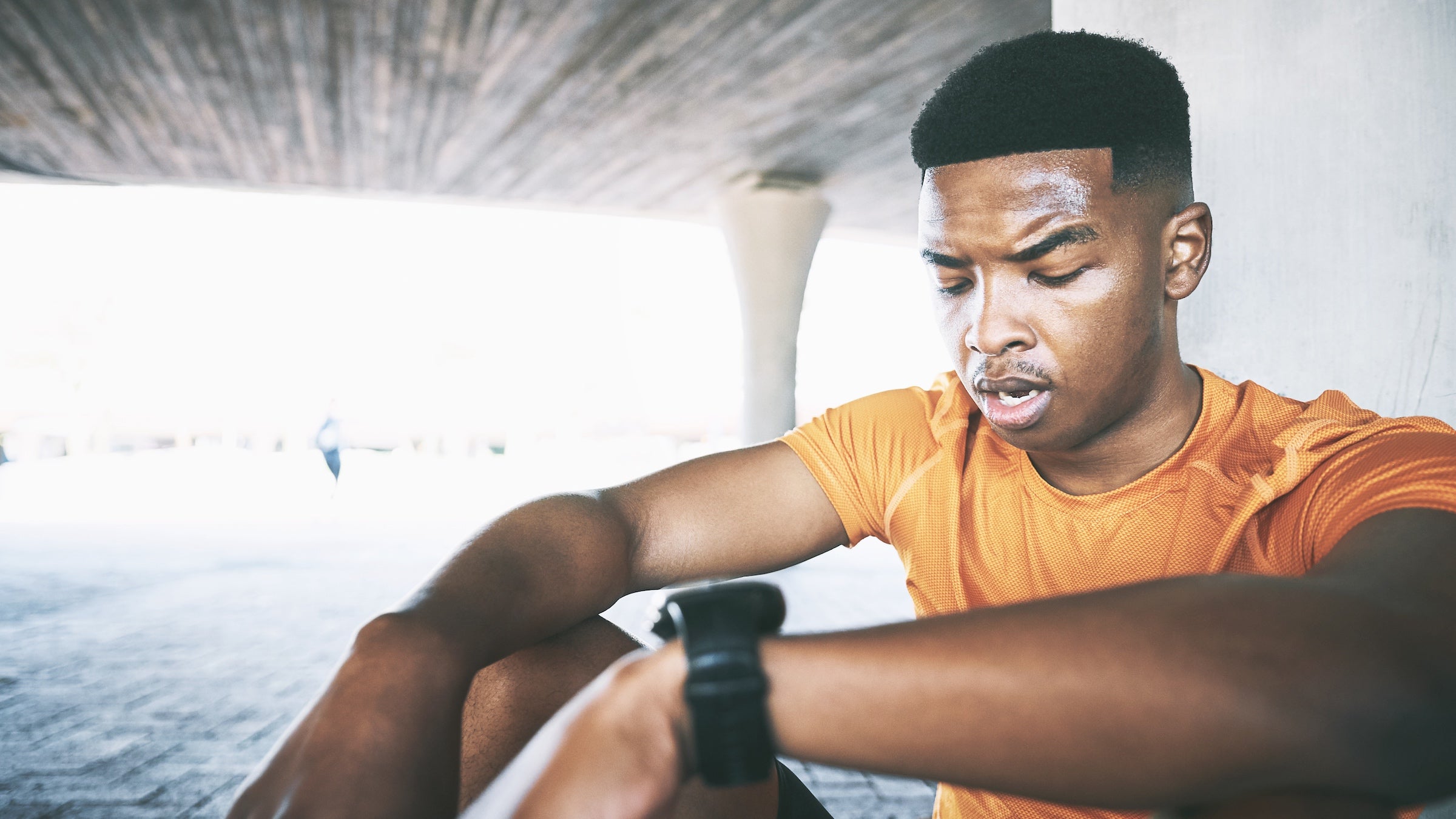 Shot of a young man taking a break after his workout against an urban background
