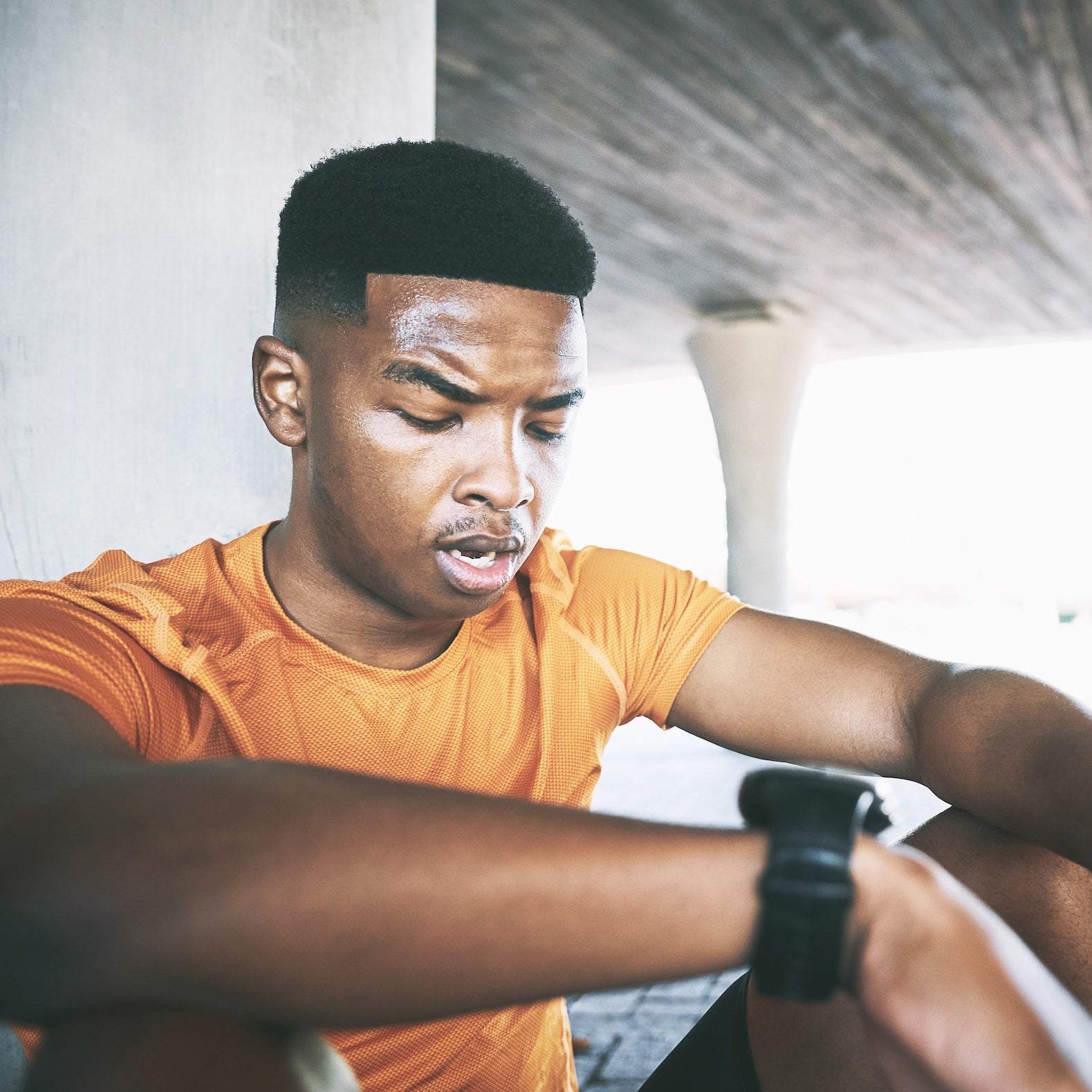 Shot of a young man taking a break after his workout against an urban background