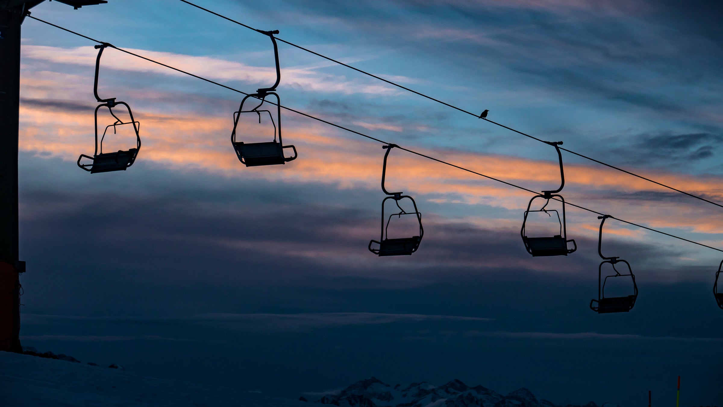 Chairlift against a dark winter sunset