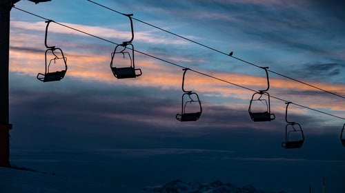 Chairlift against a dark winter sunset