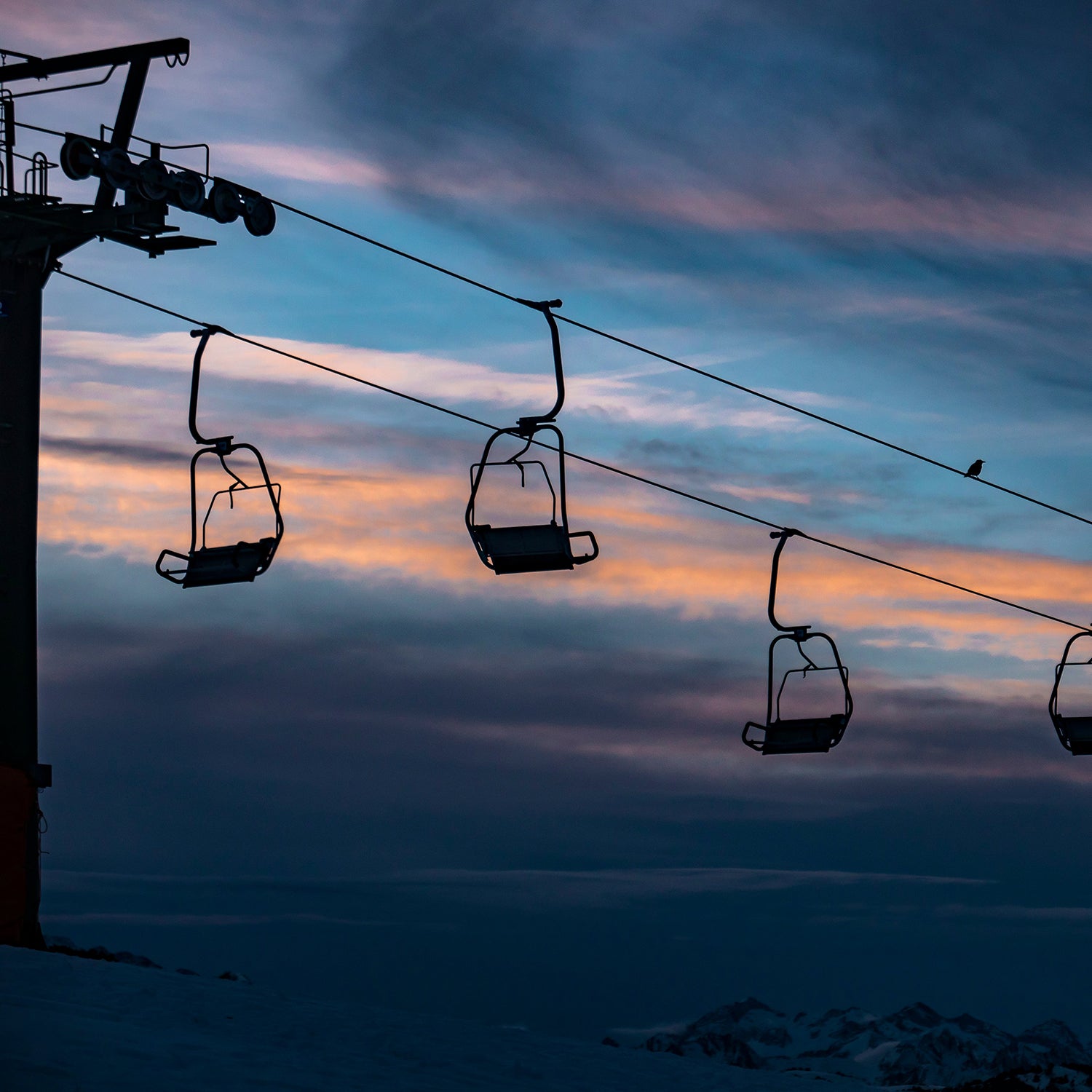 Chairlift against a dark winter sunset