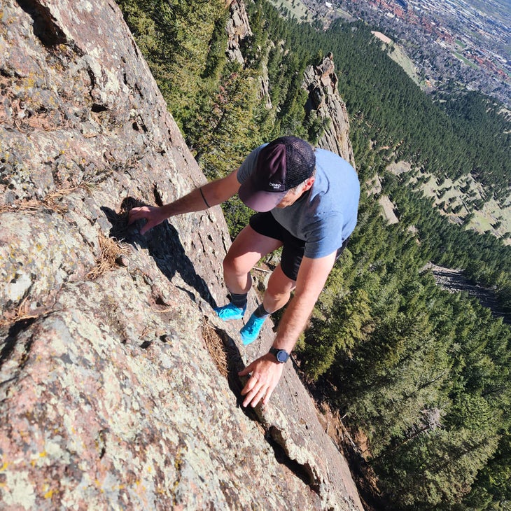 Tester scrambling up cliff in Arc'teryx Norvan SL3