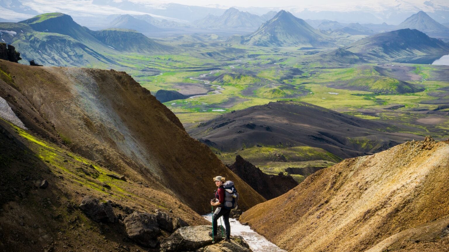 The author in Iceland in fronton a magnificent view of green valleys and pointed peaks