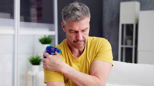 Man uses a gel ice pack on his shoulder