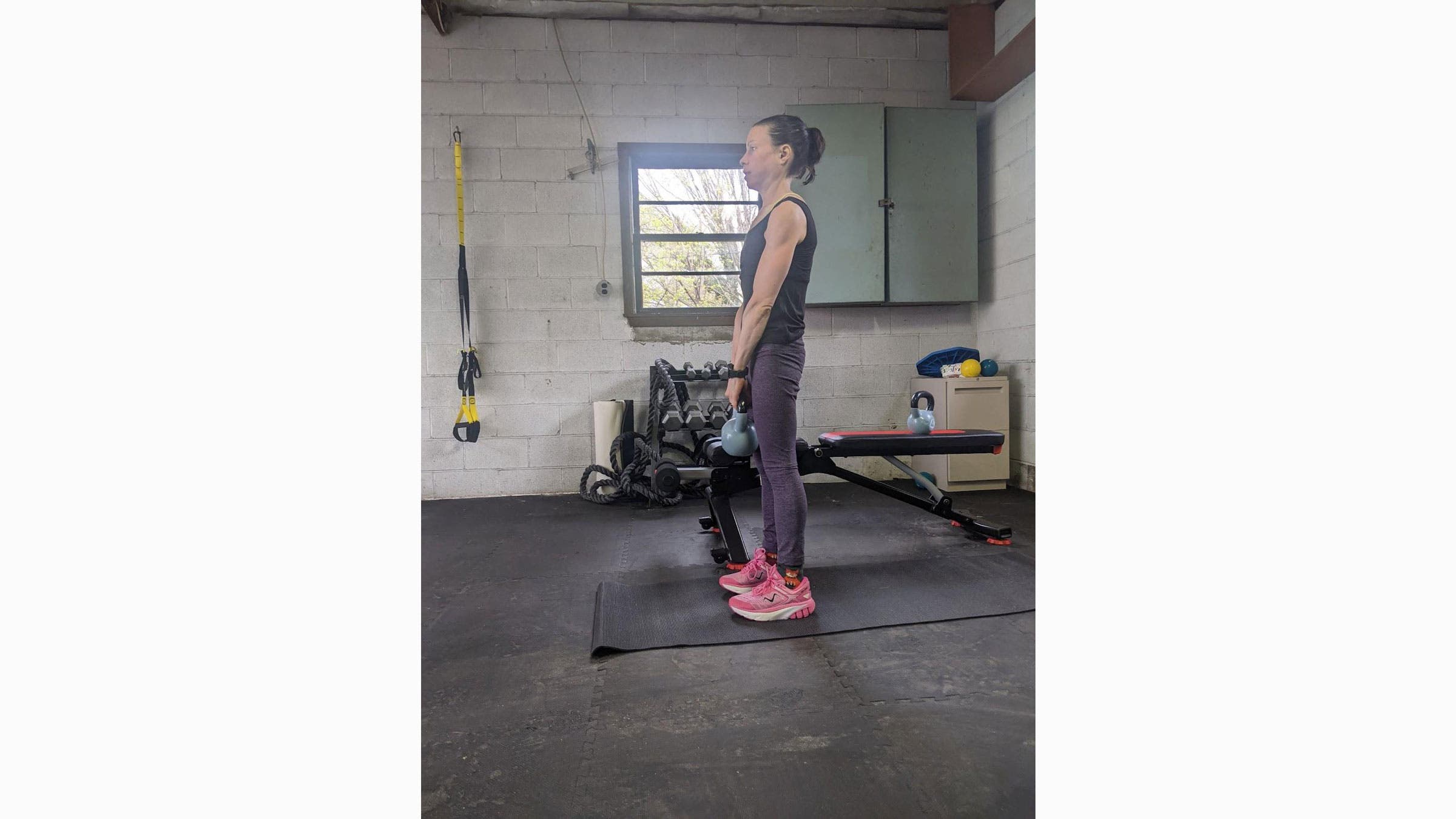 Woman practices kettlebell swings