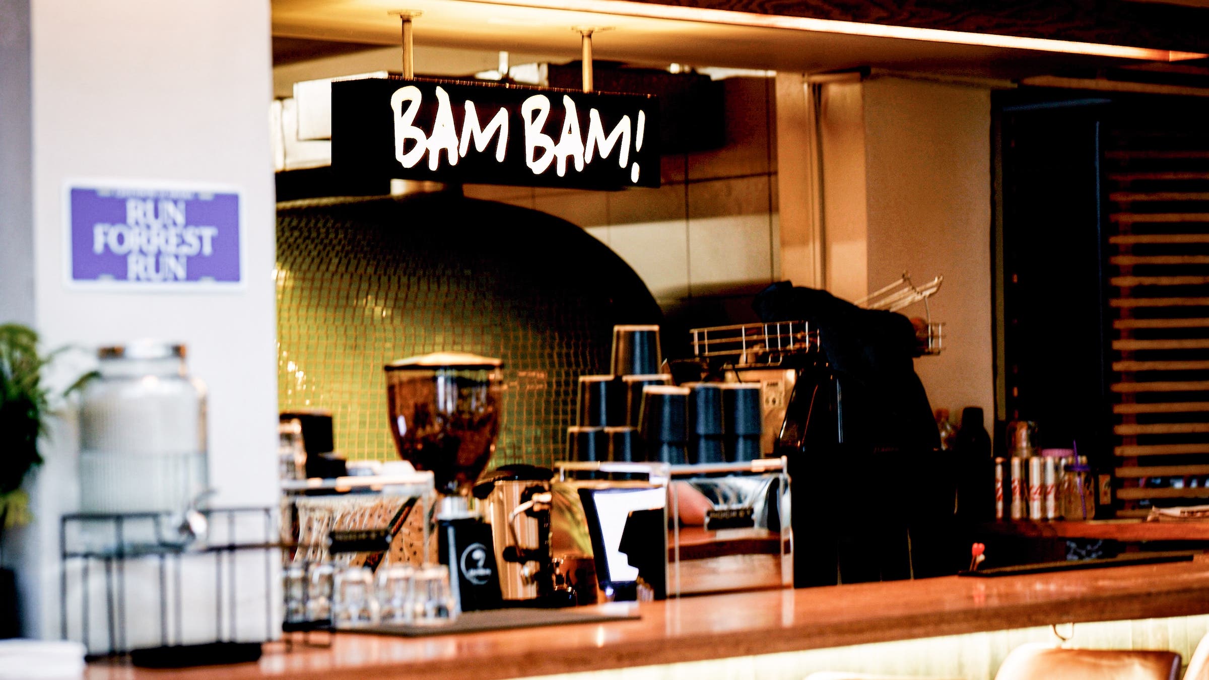 A cafe in the running store with a black sign hung that says BAM BAM