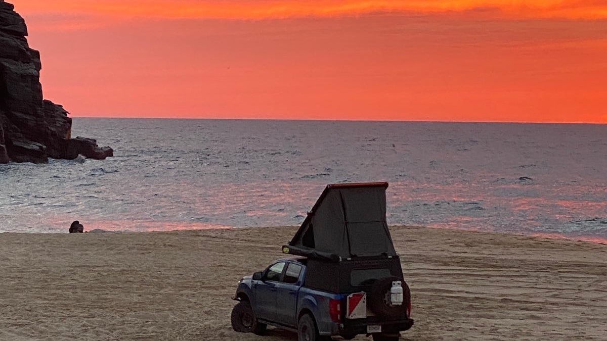 overlanding truck with camper on a beach