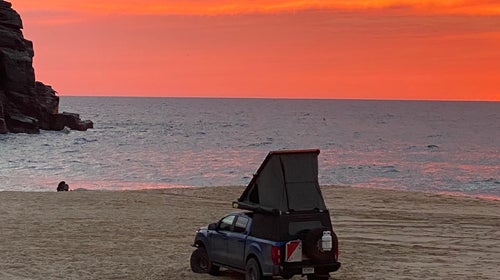 overlanding truck with camper on a beach