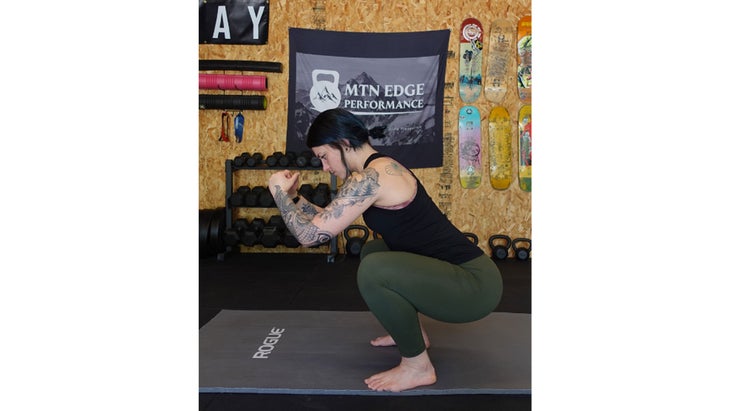 Woman demonstrates proper squat form