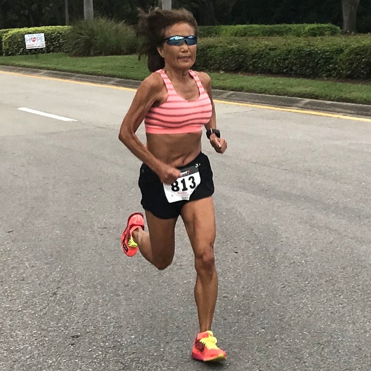 Woman in a red striped top runs a marathon
