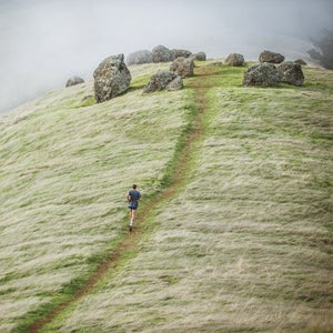 Landscape view of a runner on a grassy hill
