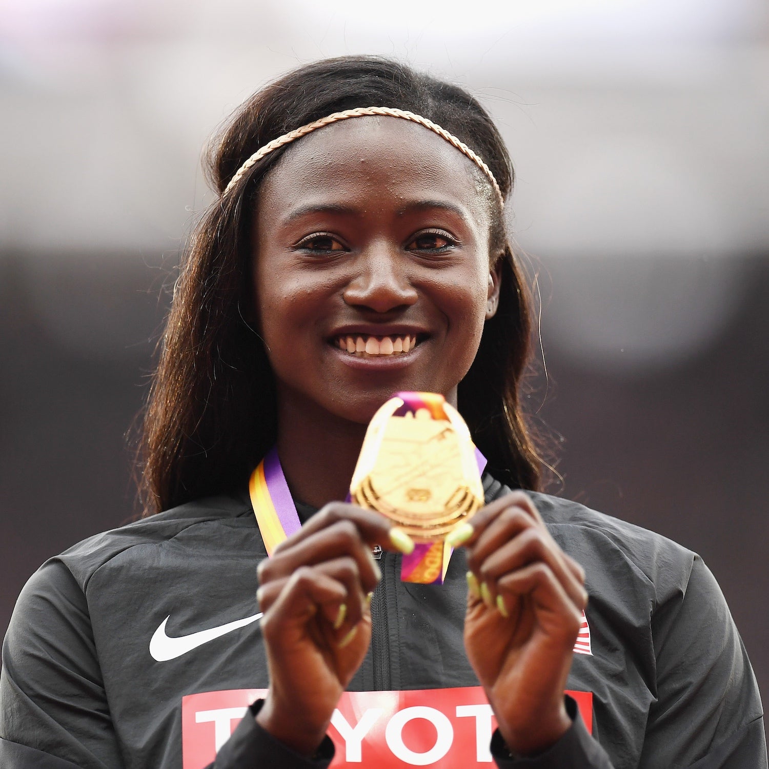 Athlete holds up an award and smiling