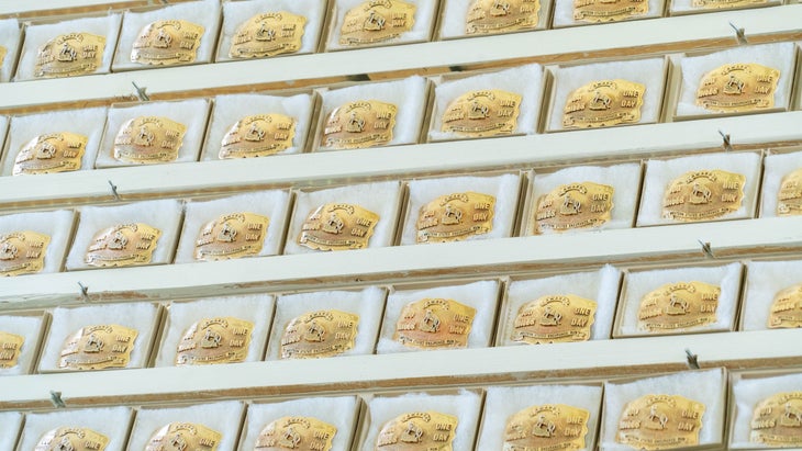 A wall full of gold belt buckles