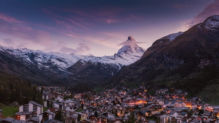 A snowcapped Matterhorn with the twinkling lights of Zermatt, Switzerland