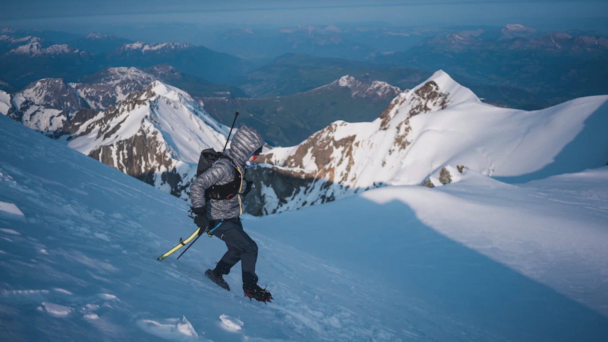 Gerardi descends a snow field with mountains in the background