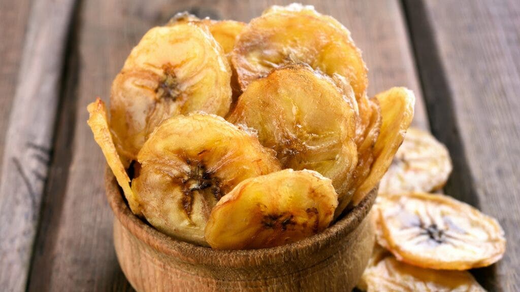 Homemade banana chips in wooden bowl