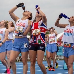 women down beers on a track before running a beer mile
