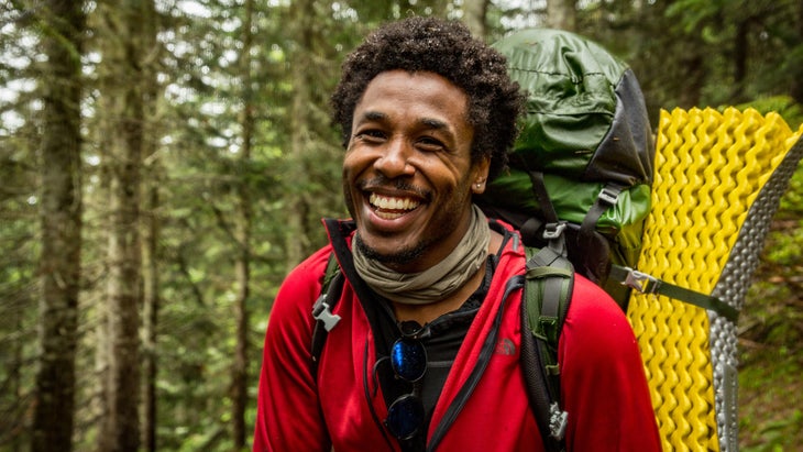 smiling man backpacking