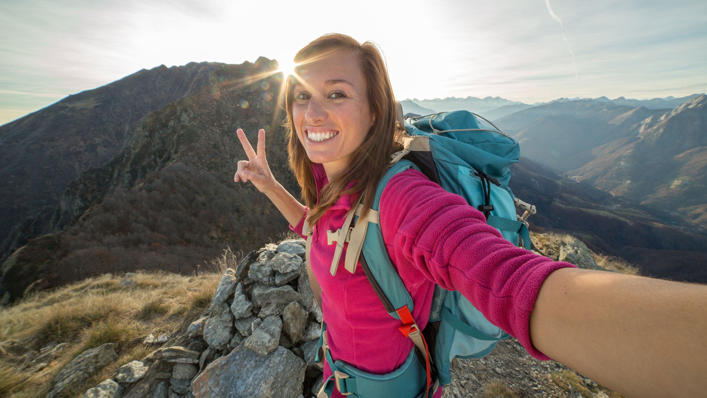 happy woman hiker trekking on trail in mountains. Girl hiker