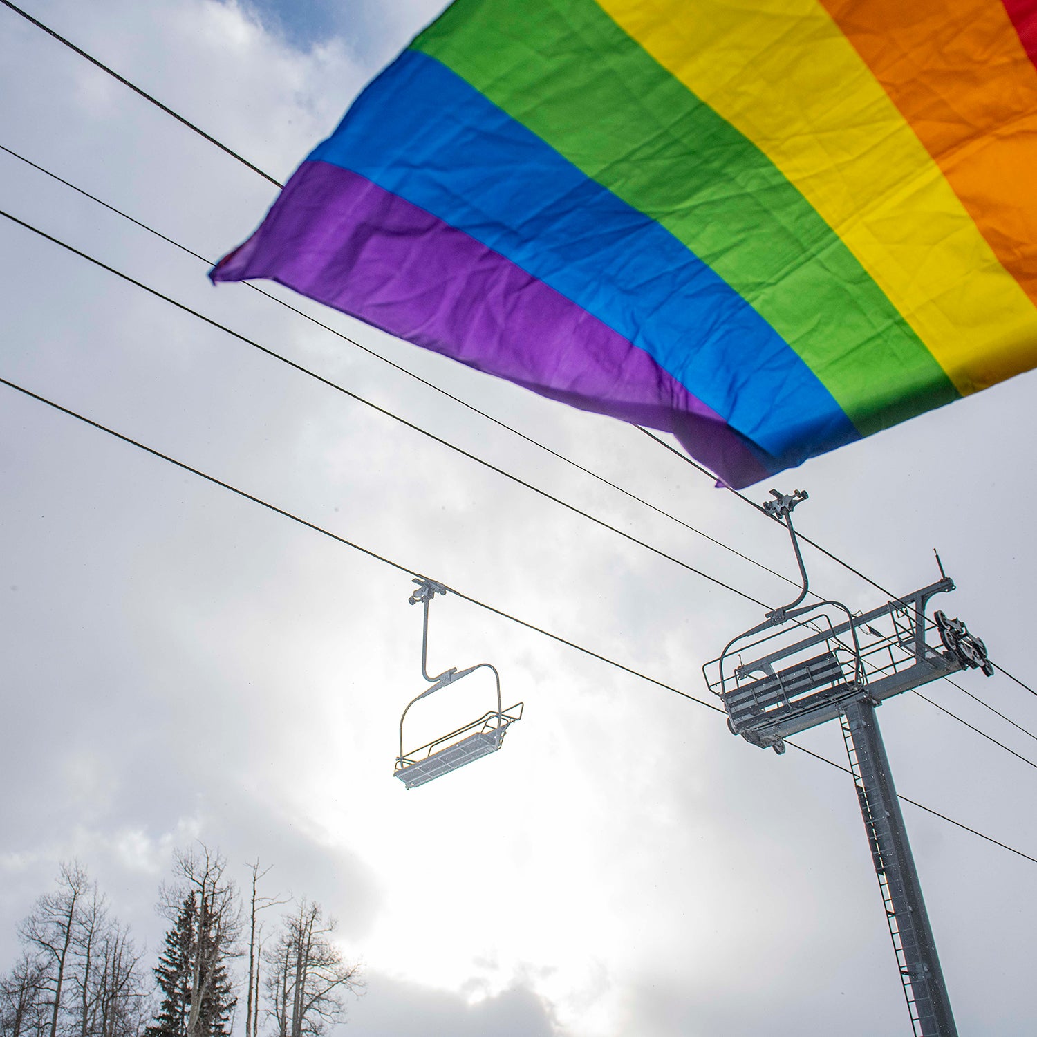 A pride flag waves in the wind under a lift in Mountain Village during Telluride Gay Ski Week in Mountain Village.