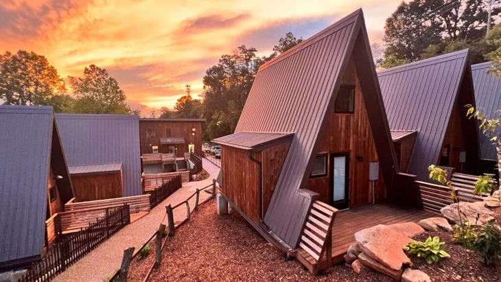 A pastel colored sunset over the A-frame cabins