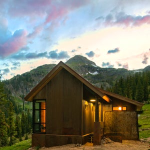 The Thelma Hut at Campfire Ranch Red Mountain Pass set against a backdrop of mountains and forest