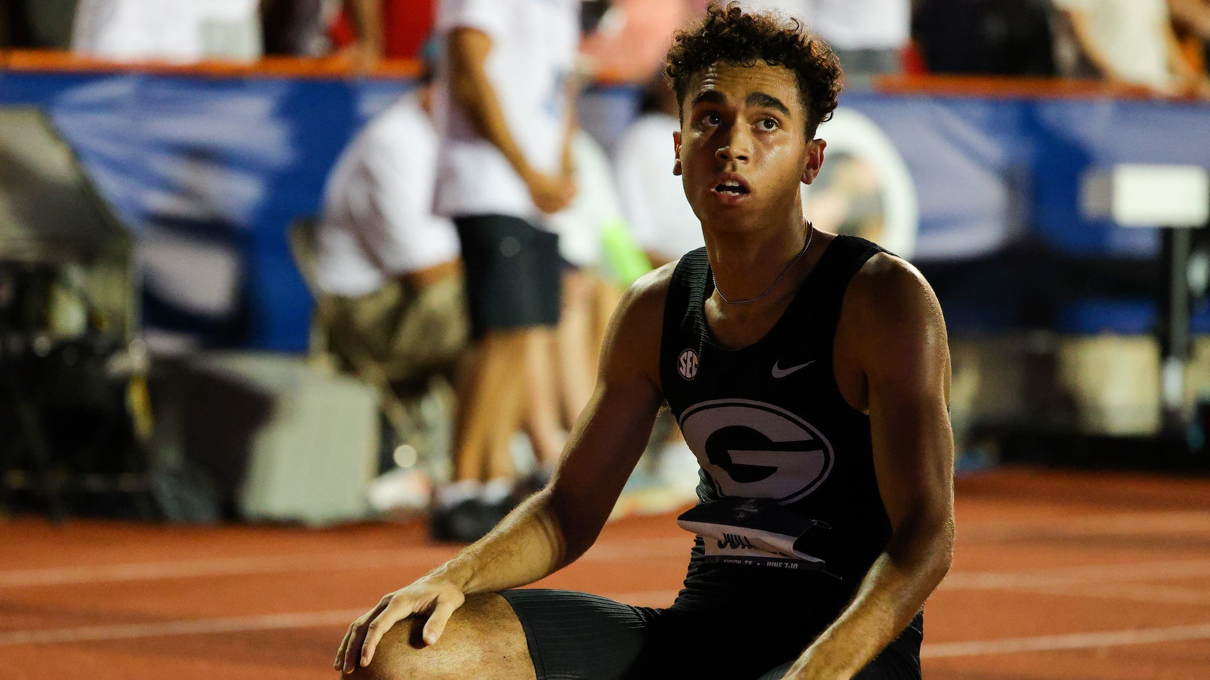 a runner sits on the track after a victorious run