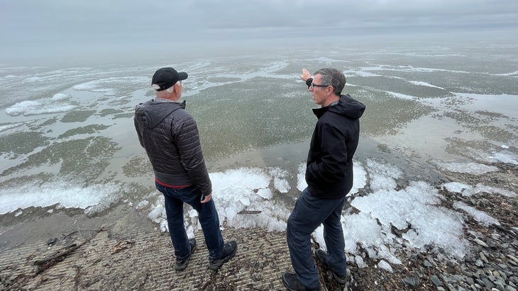 Two men assess the ice levels in a lake near the start of the Mississippi River