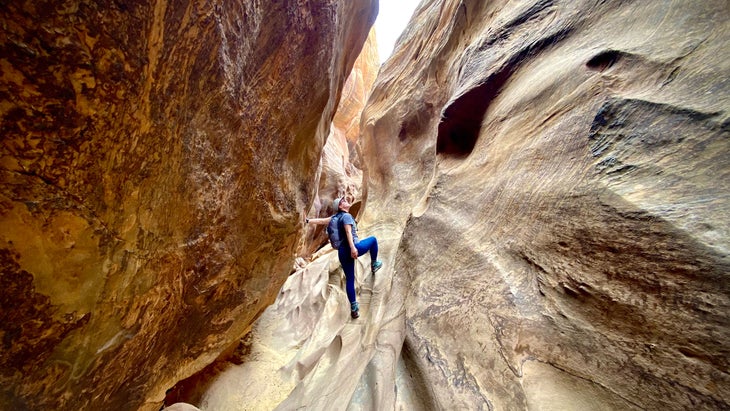 hiker exploring a slot canyon in Capitol Reef National Park