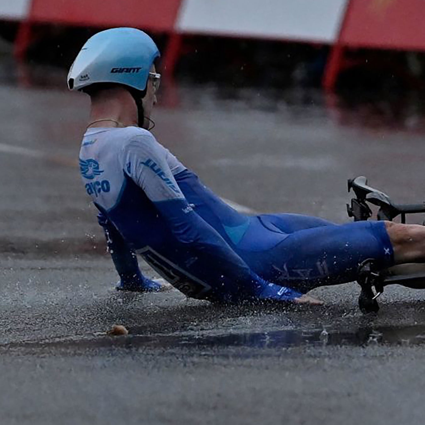 A cyclist crashes on his aerodynamic time trial bike.