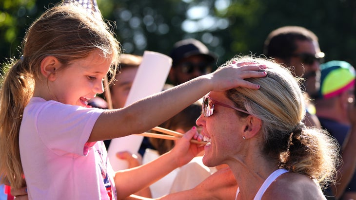 A woman and her daughter embrace after finishing a marathon