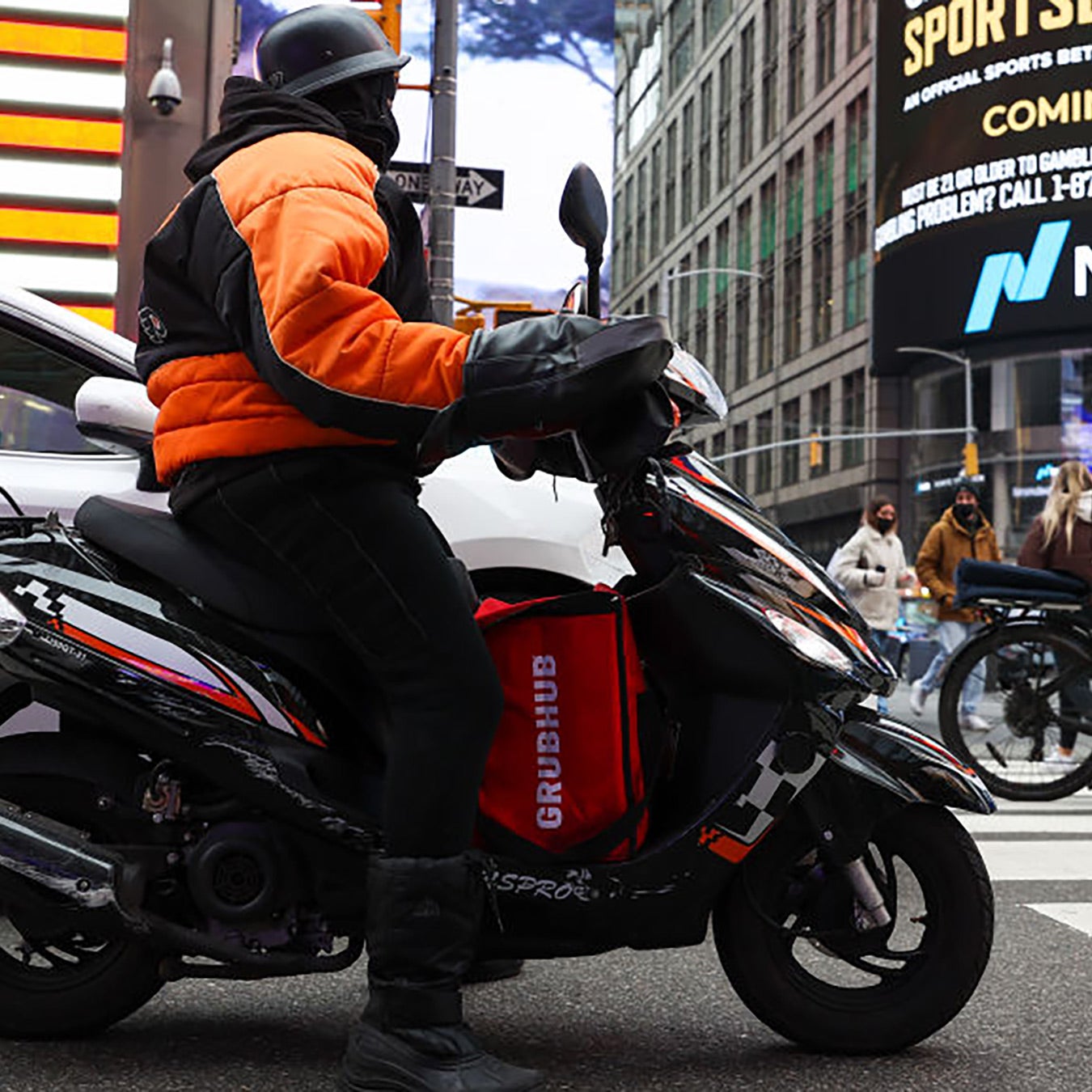 A motor scooter rides through Times Square