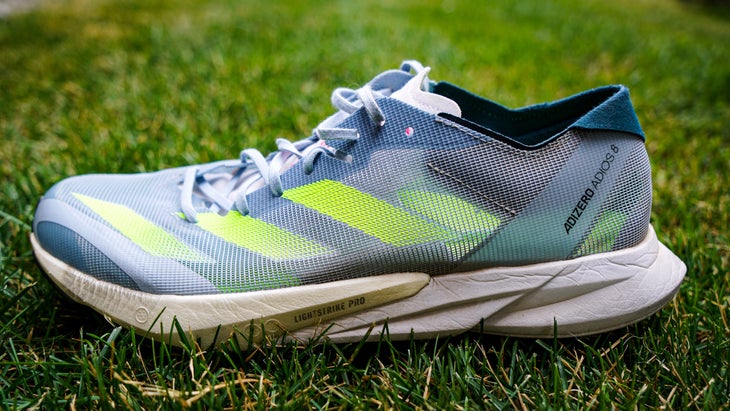 A shoe with green stripe in the grass