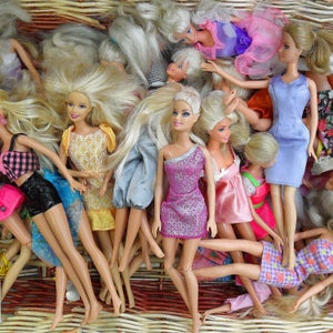 Pile of barbie dolls in a basket