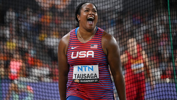 A woman celebrates after winning a discus toss 