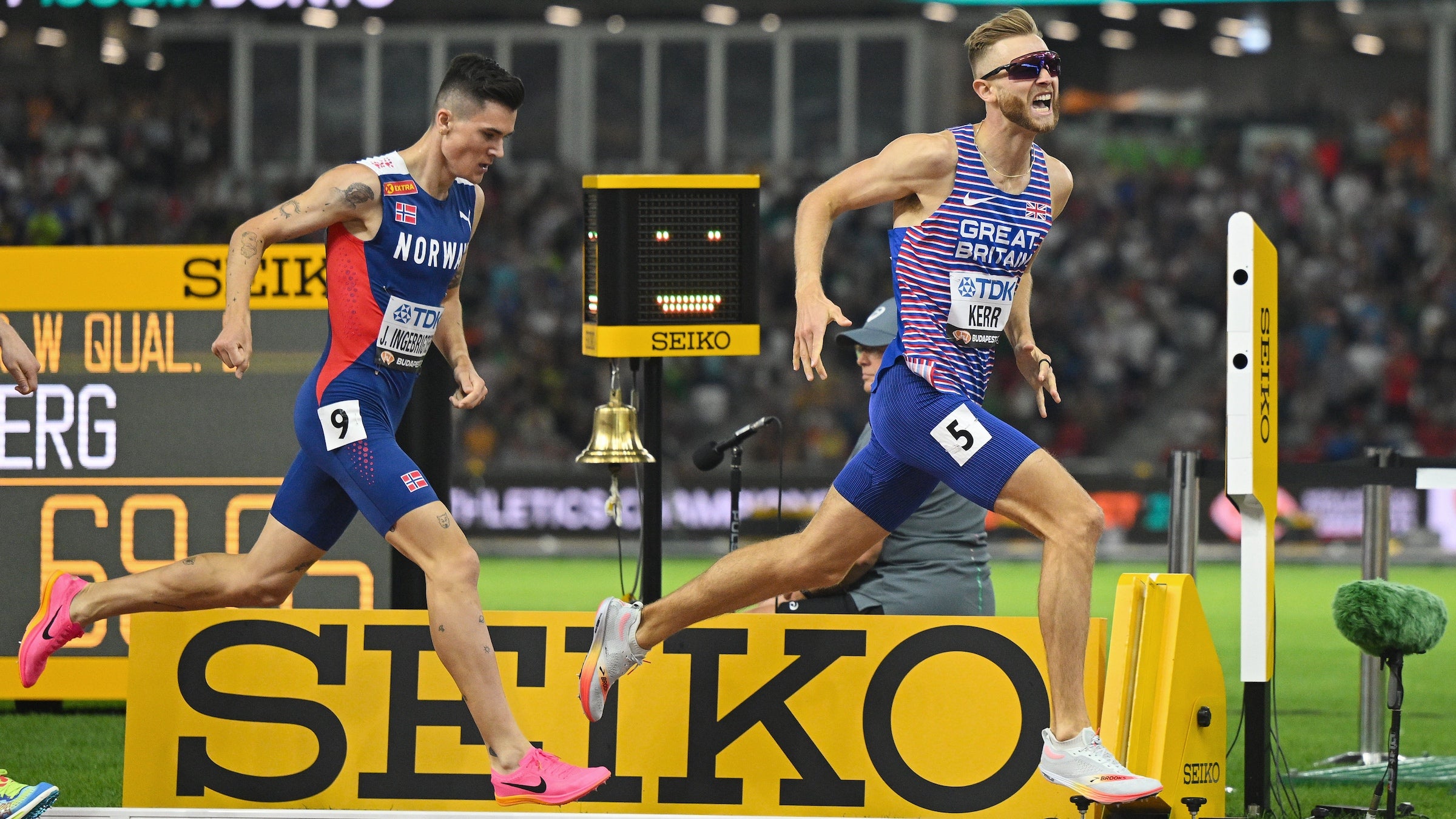 Two men gun for the finish, one in blue and other in purple and red