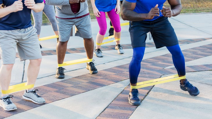 A group of people do lateral band walks