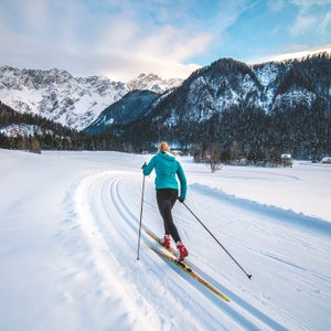 nordic skier in classic tracks with mountain background