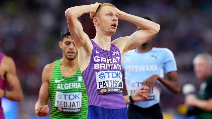 A man wearing purple reacts after finishing a race
